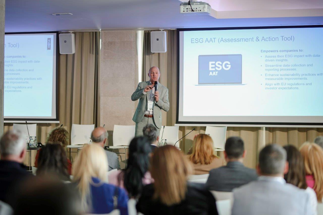 Tomi Ilijaš, CEO of Arctur, speaks at the Ecoforum in Herceg Novi, presenting in front of an audience with two large screens showing "ESG AAT (Assessment & Action Tool)" on the right and text on the left.