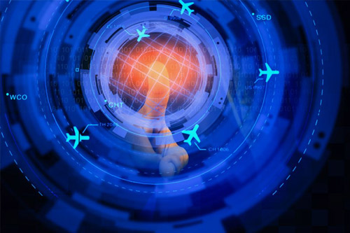A finger touches a glowing, orange holographic globe surrounded by blue, concentric rings displaying binary code, text, and icons of airplanes.
